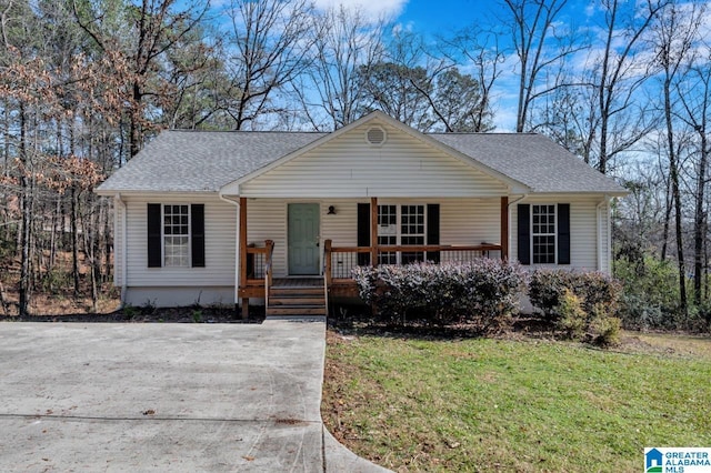 ranch-style home featuring covered porch and a front lawn