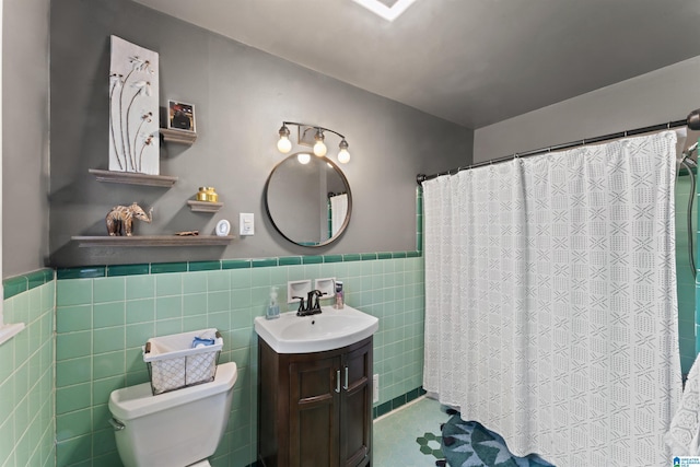 bathroom featuring vanity, toilet, and tile walls