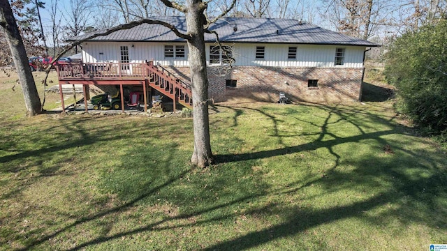 back of house featuring a lawn and a wooden deck