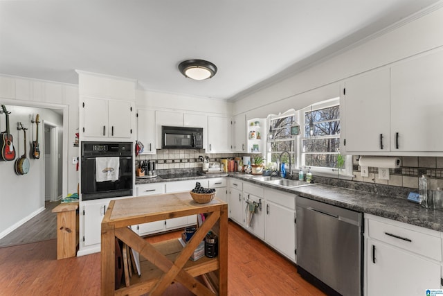 kitchen with white cabinets, sink, dark hardwood / wood-style floors, and black appliances