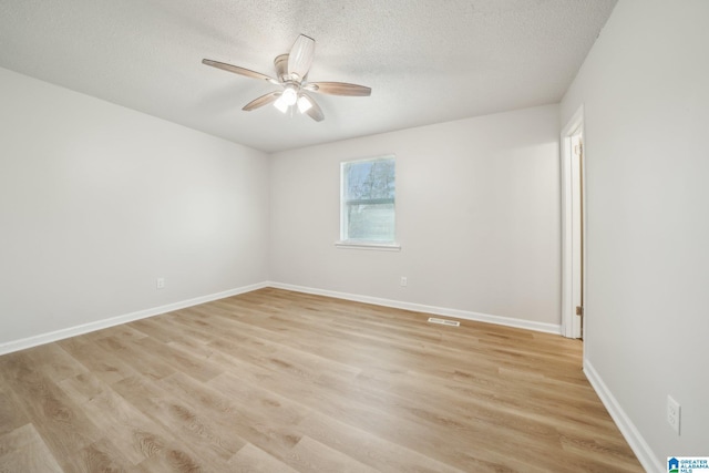 spare room with a textured ceiling, light hardwood / wood-style flooring, and ceiling fan