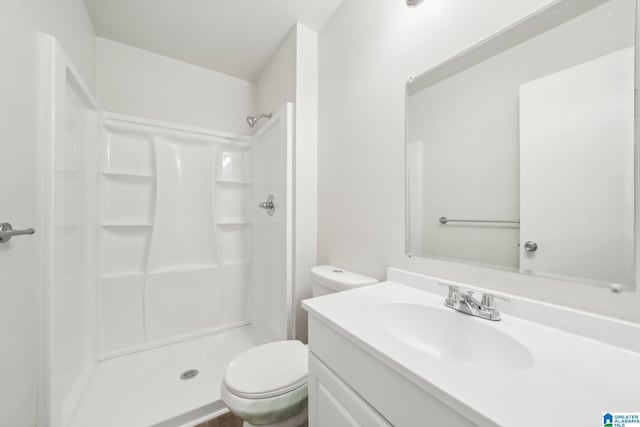 bathroom with a shower, vanity, and toilet