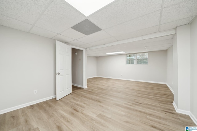 basement featuring a drop ceiling and light wood-type flooring