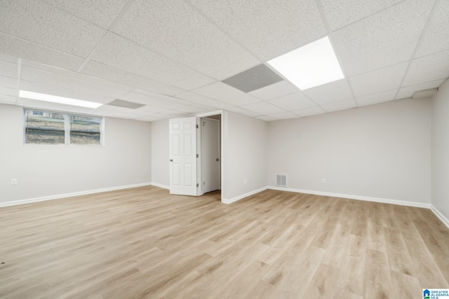 basement with light wood-type flooring and a drop ceiling