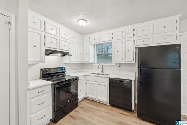 kitchen with sink, a textured ceiling, white cabinets, black appliances, and light wood-type flooring