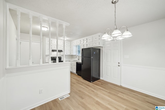 kitchen featuring black appliances, light hardwood / wood-style flooring, range hood, a notable chandelier, and white cabinetry