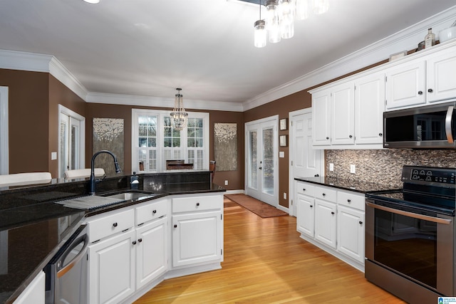 kitchen featuring white cabinets, decorative light fixtures, stainless steel appliances, and a notable chandelier