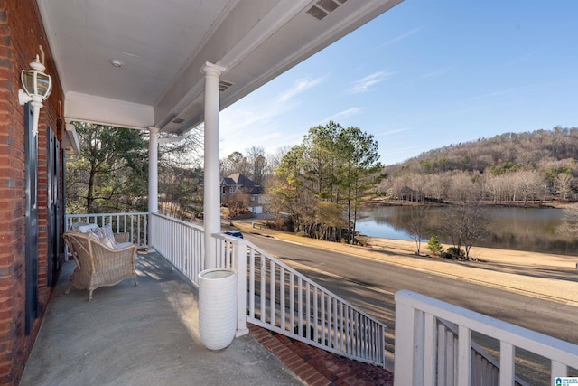 balcony featuring a water view and a porch