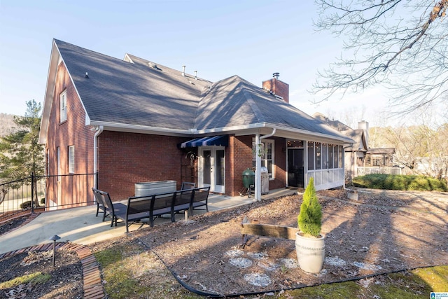 rear view of house with a patio area, a jacuzzi, and a sunroom