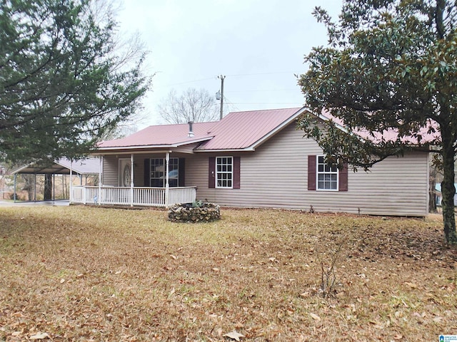 55 Jeter Rd, Talladega, AL 35160 - rear view of property featuring a carport, covered porch, and a yard