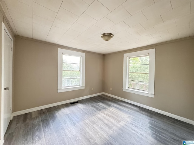 spare room with dark hardwood / wood-style floors and ornamental molding