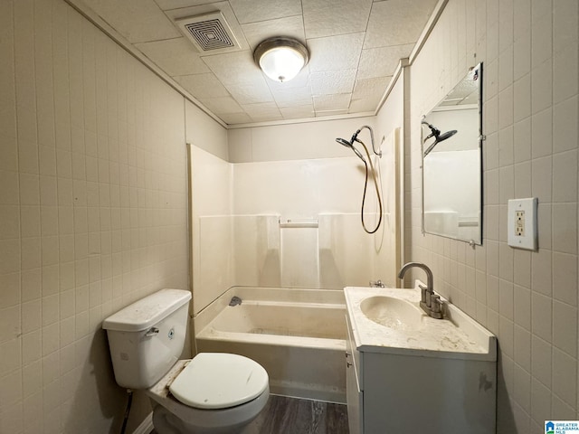 full bathroom with shower / bath combination, toilet, vanity, tile walls, and hardwood / wood-style flooring