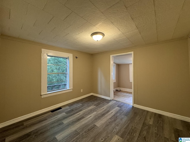 spare room featuring crown molding and dark hardwood / wood-style floors