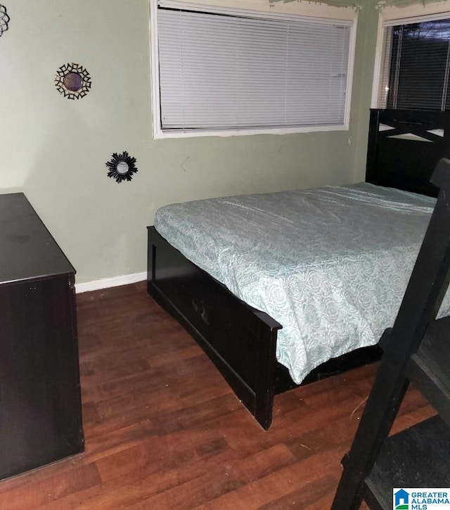 bedroom with dark hardwood / wood-style flooring