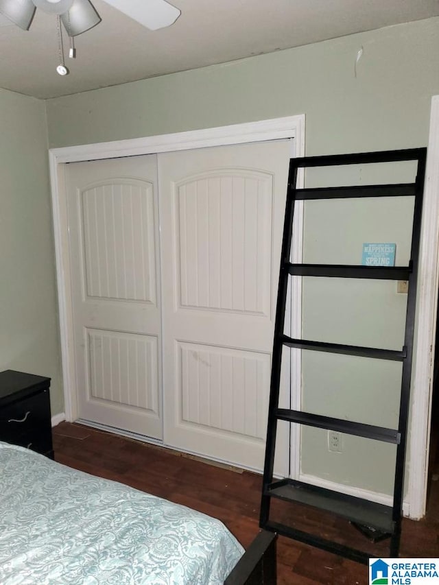 bedroom with dark wood-type flooring, ceiling fan, and a closet