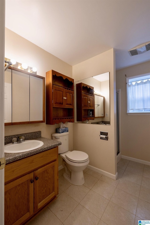 bathroom with toilet, vanity, tile patterned floors, and an enclosed shower