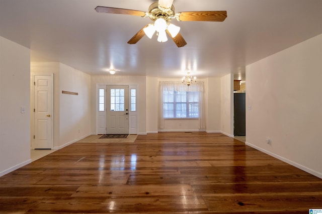 unfurnished living room with dark wood-type flooring and ceiling fan with notable chandelier