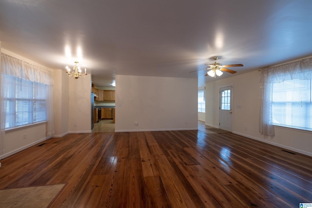 unfurnished living room featuring dark hardwood / wood-style flooring and ceiling fan with notable chandelier