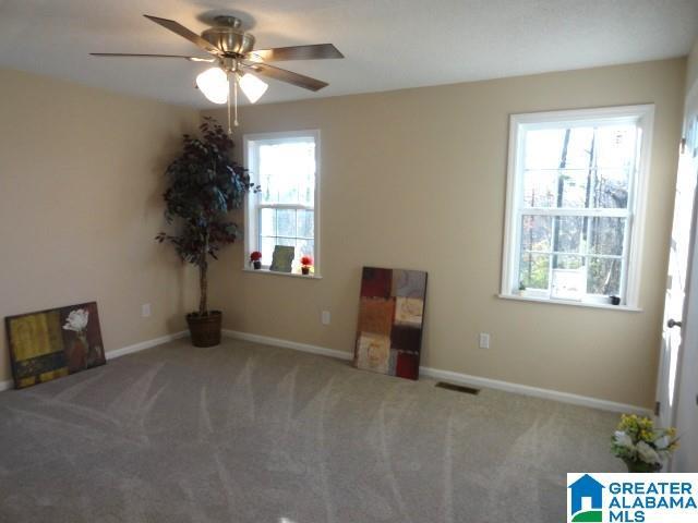 carpeted spare room with ceiling fan