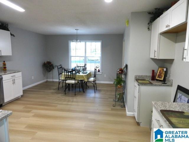 dining space with an inviting chandelier and light wood-type flooring