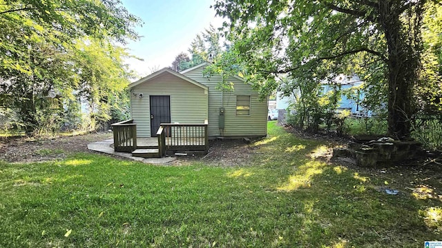 rear view of property featuring a yard and a wooden deck