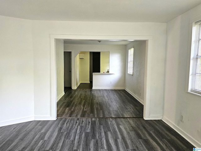 empty room with plenty of natural light and dark hardwood / wood-style floors