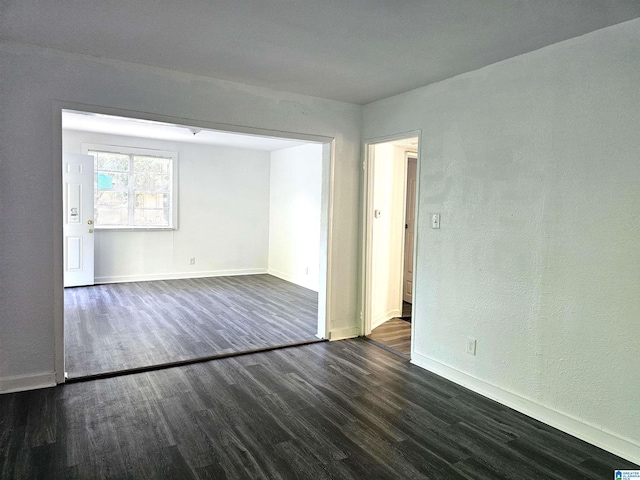 unfurnished room featuring dark wood-type flooring