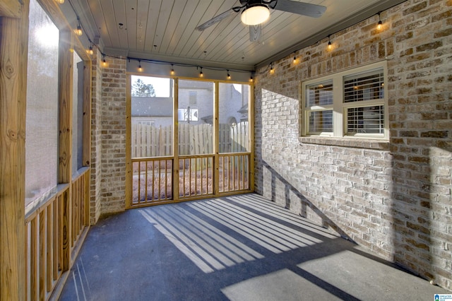 unfurnished sunroom with track lighting, ceiling fan, and wooden ceiling