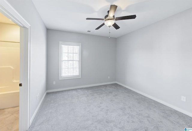 carpeted spare room featuring ceiling fan