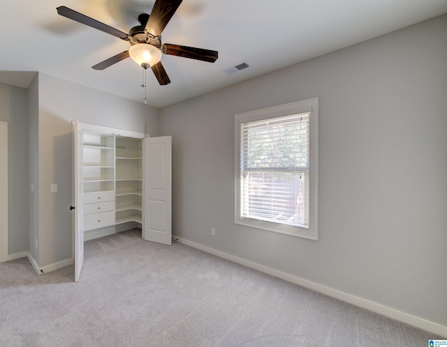 unfurnished bedroom featuring ceiling fan, a closet, and light carpet