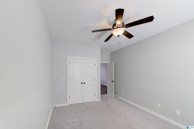 unfurnished bedroom with ceiling fan, a closet, and light colored carpet