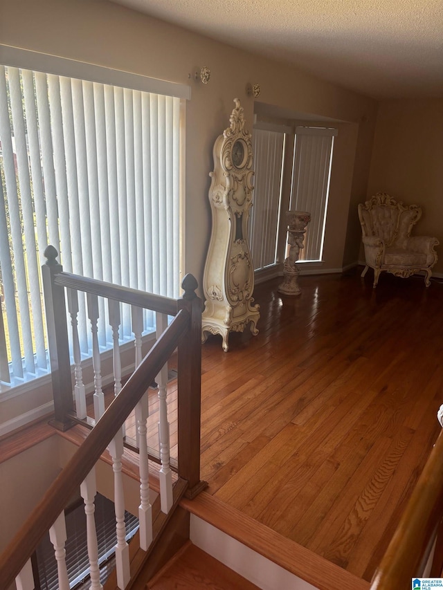 staircase featuring hardwood / wood-style flooring and a textured ceiling