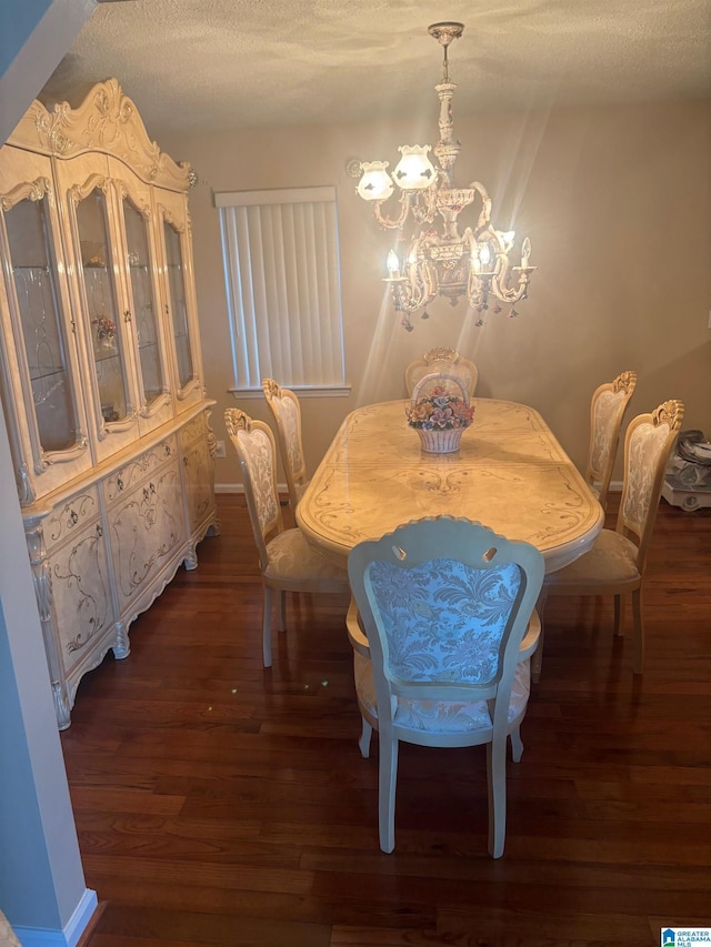 dining room with a textured ceiling, dark wood-type flooring, and a chandelier