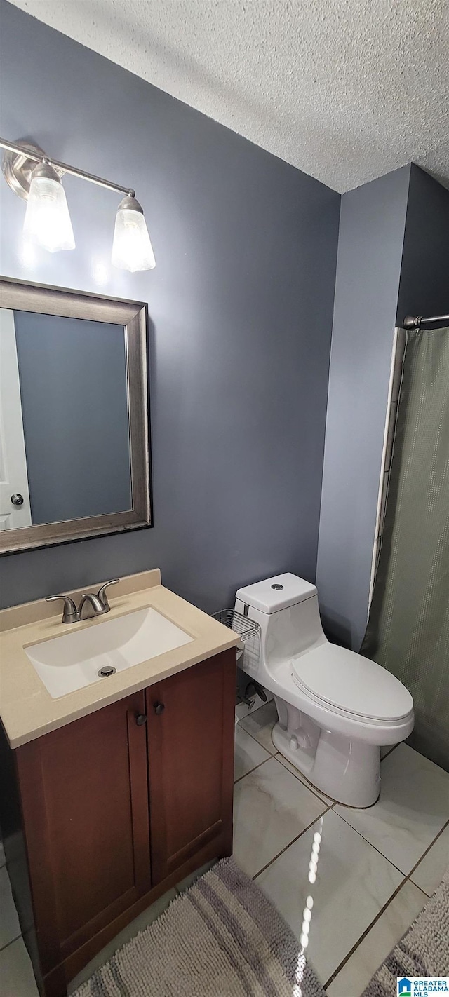 bathroom featuring toilet, vanity, and a textured ceiling