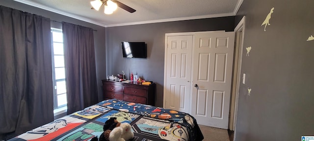 bedroom with a textured ceiling, ceiling fan, ornamental molding, and a closet