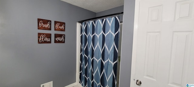 bathroom featuring tile patterned flooring, a textured ceiling, and a shower with shower curtain