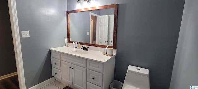 bathroom with toilet, vanity, and tile patterned flooring