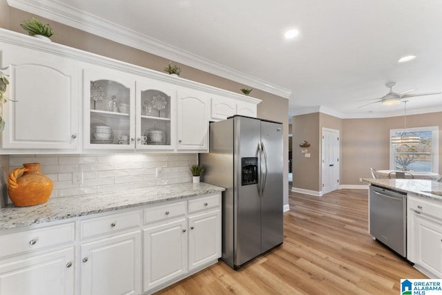 kitchen with ceiling fan, white cabinetry, stainless steel appliances, and tasteful backsplash