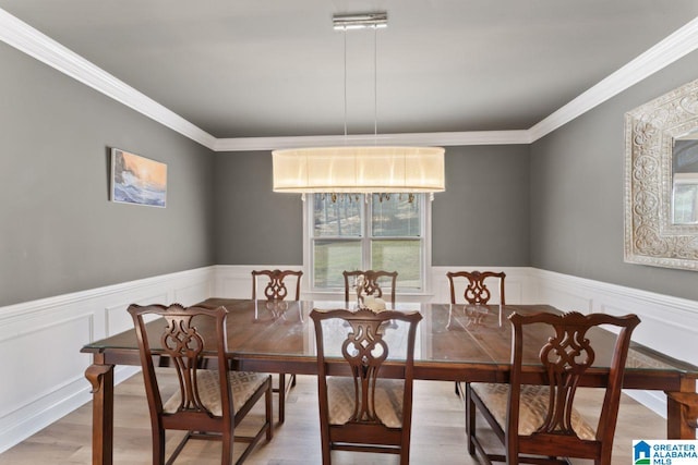 dining space with wood-type flooring and ornamental molding