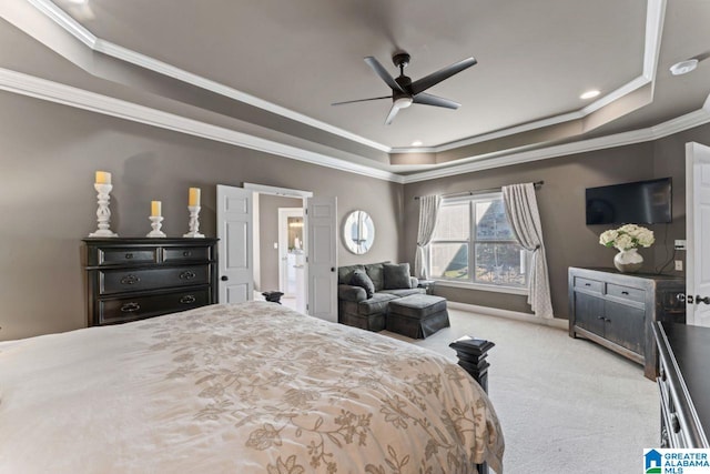 carpeted bedroom with a raised ceiling, ceiling fan, and crown molding