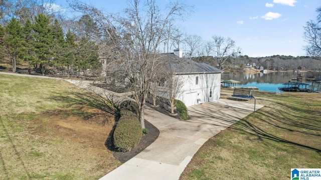 exterior space with a water view and a lawn