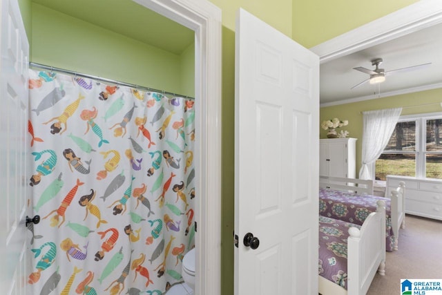 bathroom featuring toilet, ceiling fan, and ornamental molding