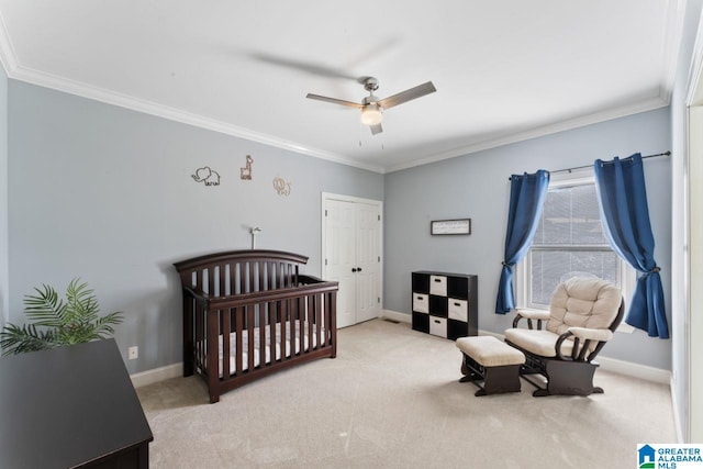 bedroom with ceiling fan, light colored carpet, a crib, and ornamental molding