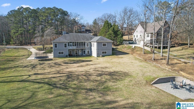 rear view of house featuring a patio and a lawn