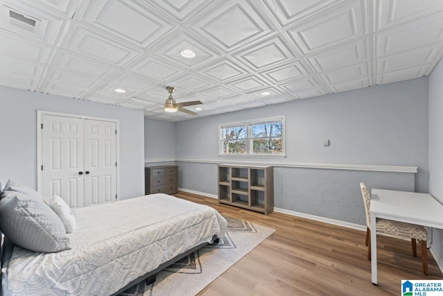 bedroom featuring hardwood / wood-style flooring, ceiling fan, and a closet