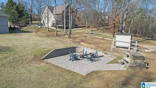 view of yard featuring a patio area and an outdoor stone fireplace