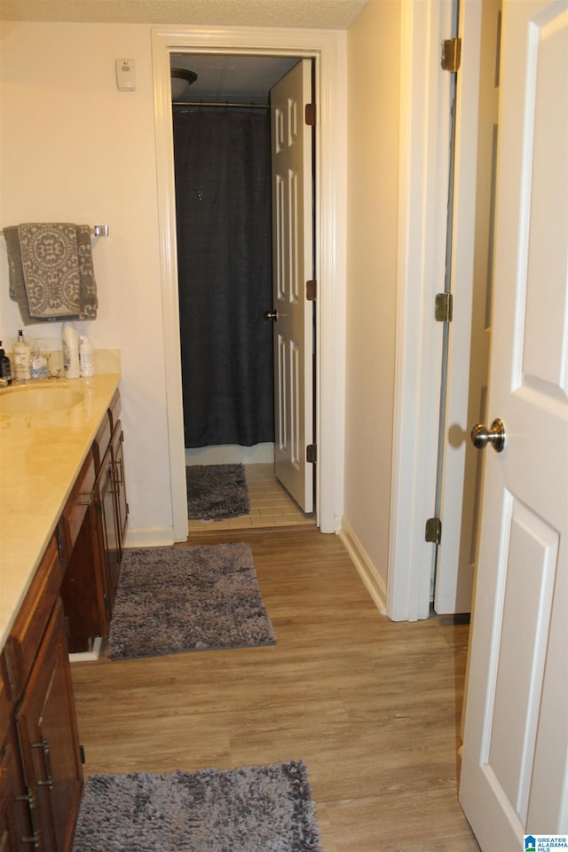 bathroom featuring hardwood / wood-style floors, vanity, and a textured ceiling