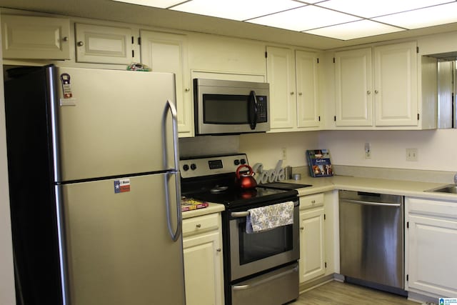 kitchen with white cabinets, stainless steel appliances, and light hardwood / wood-style flooring