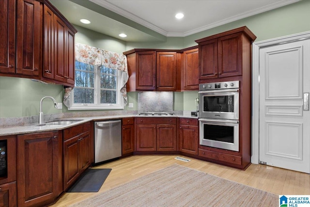 kitchen featuring sink, stainless steel appliances, light hardwood / wood-style flooring, decorative backsplash, and ornamental molding