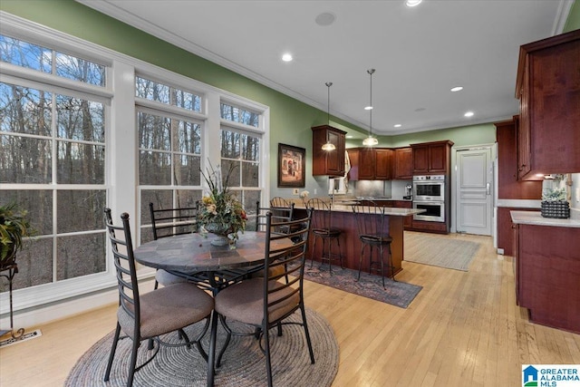 dining area featuring a wealth of natural light, light hardwood / wood-style flooring, and ornamental molding